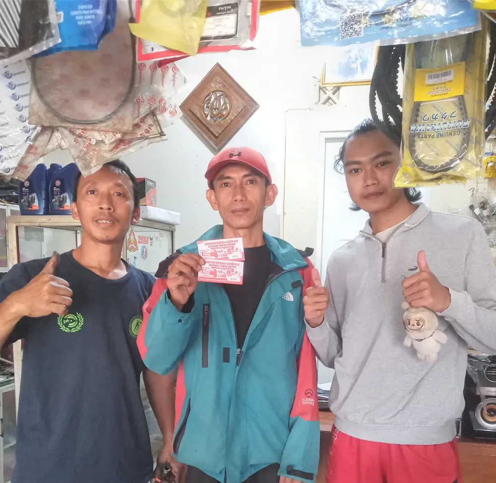 Tiga orang di bengkel menunjukkan kupon undian
